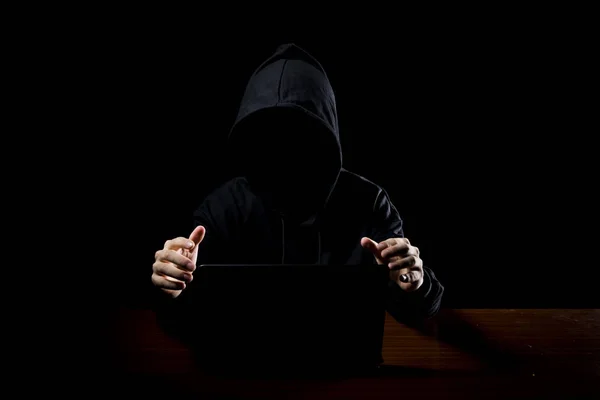 Hacker in front of his computer. Dark face