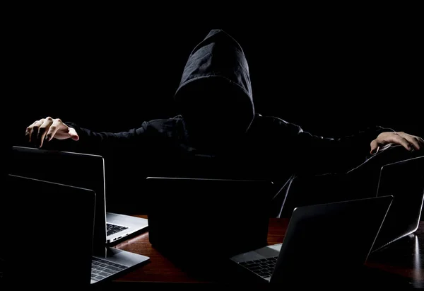 Hacker in front of his computer. Dark face