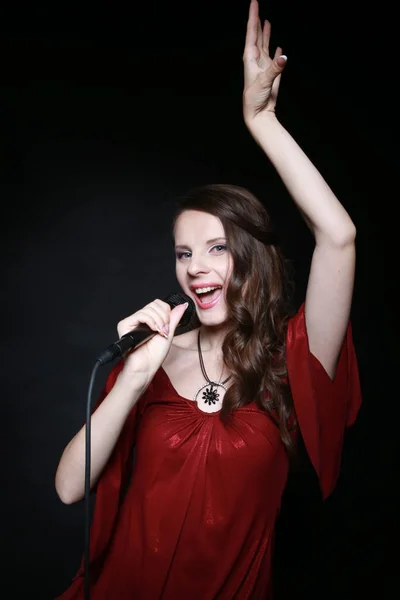 Young beautiful woman singing into a microphone