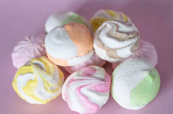 Kolorowe marshmallows-zephyrs na różowym tle. Kolorowe Bezy na różowym. Wiele słodkich zephyrs. Modny obraz deser widok z góry. — Zdjęcie stockowe