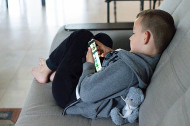 Cep telefonuyla oynayan çocuk. küçük çocuk akıllı telefon bakar