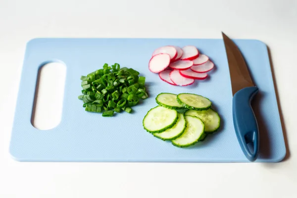 Sliced radish, Cucumber, Green onion on the blue slate board, top view. Ingredients for vitamin spring salad