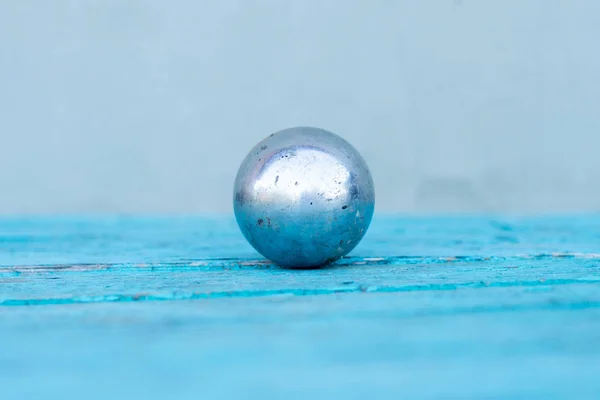 closeup of old metal sphere on wooden background