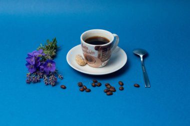 Fincan kahve ve Beyaz Lale mavi zemin üzerine Minimalistc resmi. Bahar kahve kavramı. Üstten Görünüm, düz yatıyordu.