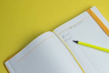 yapılacak metinli not defterini liste ve kırtasiye malzemeleri, renkli kalemler ve sarı arka plan üzerinde cetvel