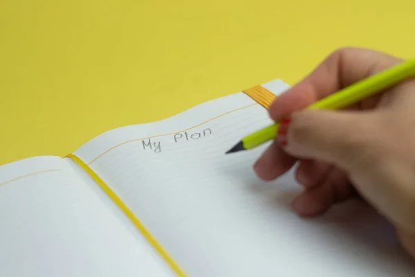 Plan metnim ve sarı arka plan üzerinde renkli kalemler, üst görünüm, düz döşeme ile defter. Stok Resim