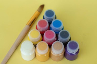 Sarı bir arka plan üzerinde akrilik boya ile çok renkli plastik olabilir. Sanat malzemeleri. Sanatçı ve yaratıcılık için ayarlayın.