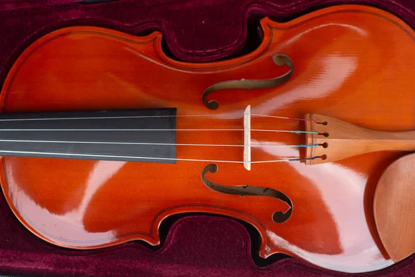 En del av en orange violin i ett Bourgogne sammet fall. — Stockfoto