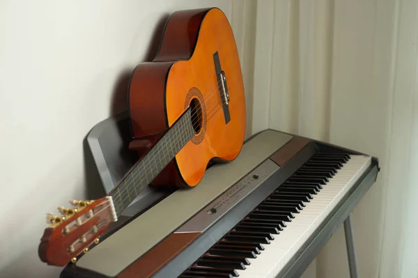 Elektronische piano keyboard en oranje gitaar. Muziekinstrumenten — Stockfoto