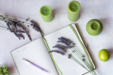 Planlama süreci. Beyaz arka plan üst görünümünde lavanta çiçek dalları, mumlar ve klavye yakın yapılacaklar listesi ile Notebook