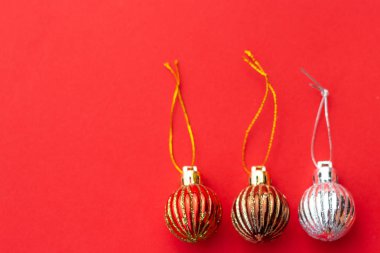 Noel kompozisyonu. Kırmızı arka plan üzerinde Noel kırmızı ve altın süslemeler. Noel topları, kurutulmuş portakallar, ev yapımı oyuncaklar. Düz döşeme, üst görünüm, kopyalama alanı