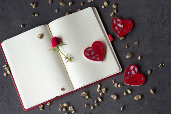 Red rose and hearts arranged on an open notebook. Concept of valentine's day. Top view — Stock Photo, Image