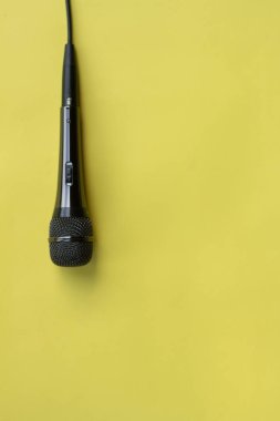 blogger, gazeteci veya müzisyen sarı arka plan üzerinde çalışmak için mikrofon. karaoke mikrofon. metin için üst görünüm alay üst görünüm alanı