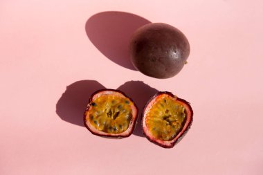 Taze tutku meyve üst görünümünde bir pastel pembe arka plan izole. Olgun tropikal tutku meyve yakın. Vejetaryen diyet tatlısı. aralıklı açlık diyeti. Sağlıklı atıştırmalık.