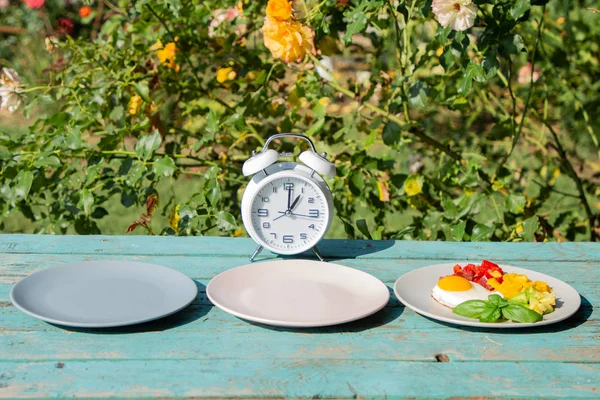 空のカラフルなプレートと断続的な断食の概念。体重を減らす時間、食事のコントロールやダイエットの概念への時間. — ストック写真