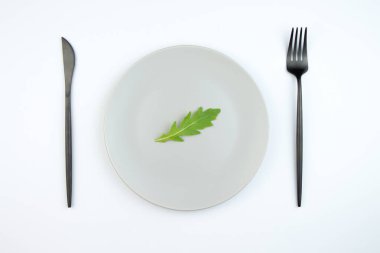 Arugula gri bir tabakta bırakır. Doğru ve diyetli beslenme kavramı.