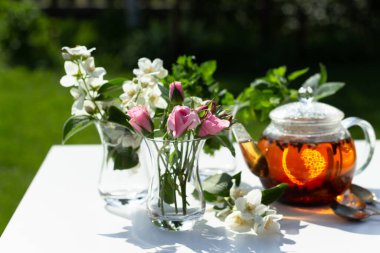 Gül, yasemin ve nane aromalı bitki çayı. Yaz güneşi ve gölgeler.