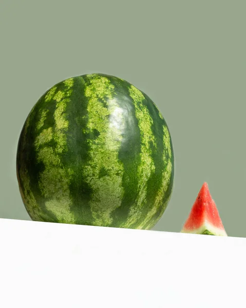 Stor fräsch vattenmelon och röd skiva vattenmelon på bordet på neo mint färgad bakgrund. Kreativ minimal sommar frukt koncept. låg vinkel vy — Stockfoto