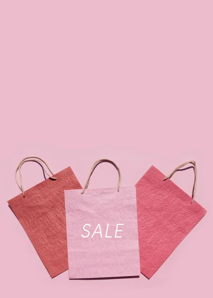 ピンクの背景にカラフルなテクスチャペーパーショッピングバッグ 最小限のファッションショッピングオンラインコンセプト コピースペース トップビュー フラットレイアウト モックアップ — ストック写真
