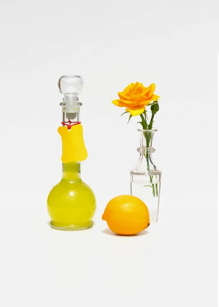 Bottle of Italian limoncello, lemon and yellow rose. Modern minimalistic still life on a geometric background with sunlight and shadows. — Stock Photo, Image