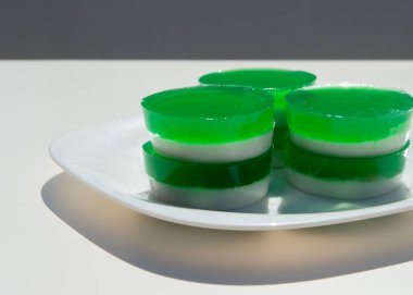 Pandanus yaprakları ve hindistan cevizi sütünden yapılmış iki katmanlı jöle. Geleneksel Tayland sokak yemekleri. Lao Wun. Modern minimalist natürmort. Doğal yeşil boya. Pandanus bir Asya vanilyasıdır..
