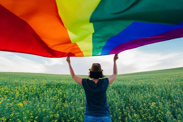 在户外绿地上高举同志彩虹旗的女人 同性夫妇的幸福 自由和爱的概念 — 图库照片