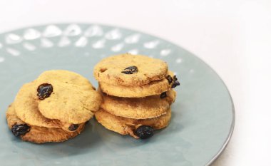 Bir plaka üzerinde üzümlü kurabiyeler. Yemek tarifleri için açık alan