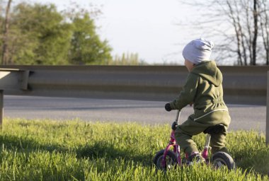 Küçük çocuk yol boyunca bir kros bisikletsürmek
