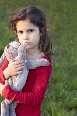 Üzgün, üzgün çocuk, korkmuş kız bahçenin ortasında yalnız. Yalnızlık ve çocuklar. Çocuk bayramı