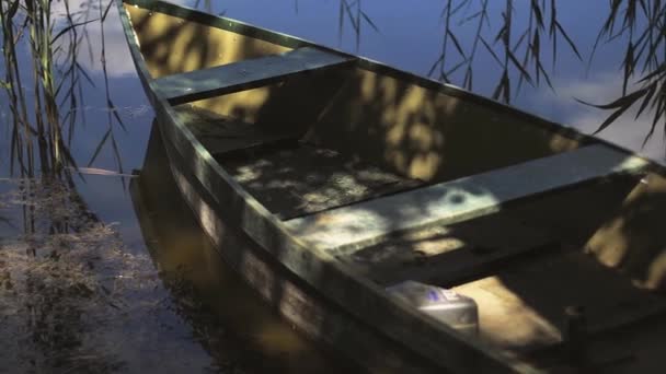 Ensam förtöjda båten flyter på en sjö eller damm. — Stockvideo