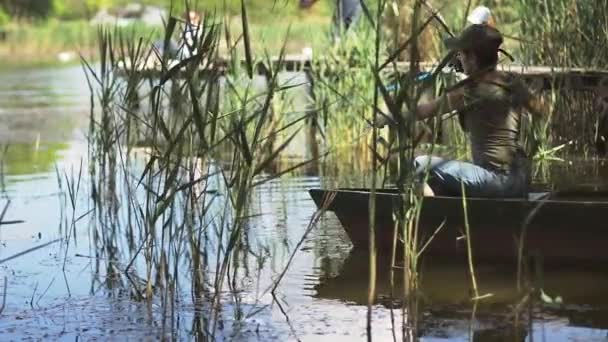 Jeune femme pêcheur pêche sur le lac de la forêt, tenant la canne à pêche tord la bobine . — Video