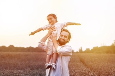 Babalar Günü. Baba ve oğul bir yaz açık havada birlikte oynarlar. Mutlu bir aile, baba, gün batımında oğul. Organik tarım ve sağlıklı yaşam tarzı, mutluluk ve sevinç kavramı