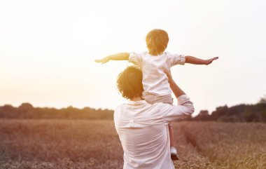 Babalar Günü. Baba ve oğul bir yaz açık havada birlikte oynarlar. Mutlu bir aile, baba, gün batımında oğul. Organik tarım ve sağlıklı yaşam tarzı, mutluluk ve sevinç kavramı