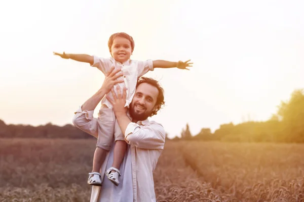 father\'s day. Dad and son playing together outdoors on a summer. Happy family, father, son at sunset. The concept of organic farming and healthy lifestyle,  happiness and joy