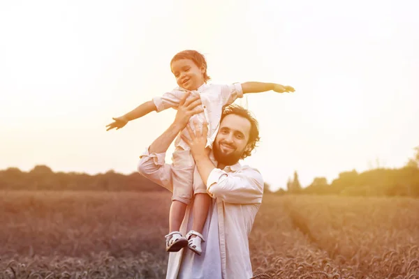 father\'s day. Dad and son playing together outdoors on a summer. Happy family, father, son at sunset. The concept of organic farming and healthy lifestyle,  happiness and joy