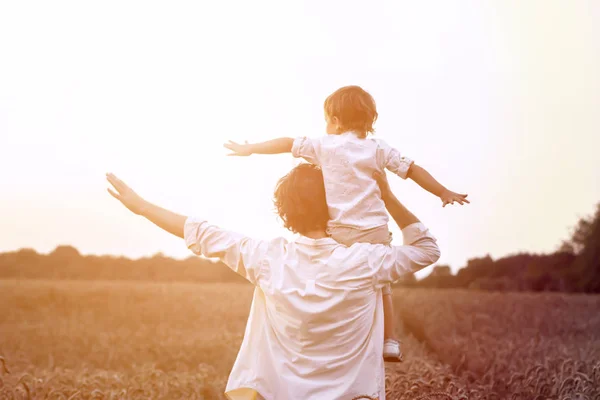 father\'s day. Dad and son playing together outdoors on a summer. Happy family, father, son at sunset. The concept of organic farming and healthy lifestyle,  happiness and joy