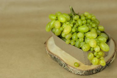 Ahşap bir stand yakın çekim üzerinde yeşil üzüm ile Kase. Sağlıklı gıda konsepti, bitkiler, toprak, organik doğal ürünler, doğal gıda, vejetaryen, sebze, çiğ, gıda festivali