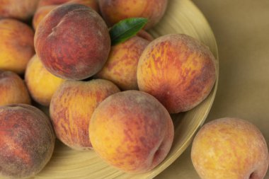 Ahşap bir arka plan üzerinde bir tabakta olgun şeftali. Close-up şeftali Sağlıklı gıda konsepti, bitki arka plan, doğal eko-ürünler, organik gıda, vejetaryen, sebze, çiğ, festival gıda