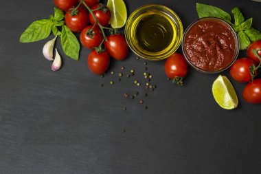 Domates salçası için İtalyan gıda maddeleri: domates, kireç, zeytinyağı, Fesleğen, siyah bir arka plan üzerinde biber. Sağlıklı gıda konsepti, bitki arka plan, doğal eko-ürünler, organik gıda, vejetaryen, sebze