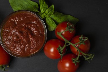Domates salçası için İtalyan gıda maddeleri: domates, kireç, zeytinyağı, Fesleğen, siyah bir arka plan üzerinde biber. Sağlıklı gıda konsepti, bitki arka plan, doğal eko-ürünler, organik gıda, vejetaryen, sebze