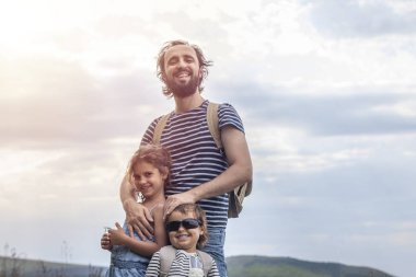 Babalar günü. Mutlu aile: baba, kız ve oğlu birlikte turist olarak seyahat, kamp gidiyor, dinlenme, seyahat. Baba, kız ve oğlu eğlenmek ve doğada oynamak, süper kahramanlar tasvir