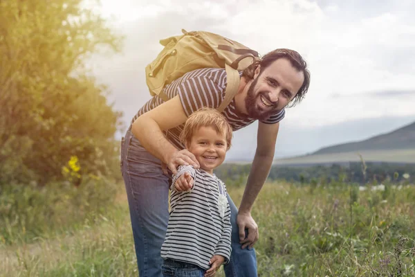 Father\'s day. Happy family: father and son travel together as tourists carry backpacks, go camping, relax, travel. Father and son have fun and play in nature