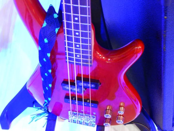 Red bass on its pedestal with strap and blue background