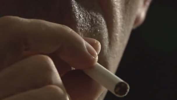 Homme fumeur allumant cigarette en arrière-plan noir 