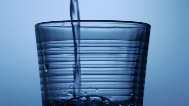 Tomber de l'eau dans un verre. Affichage de l'eau tombant dans un verre gros plan 