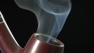 Siyah arka planda duman ile tütün borusu