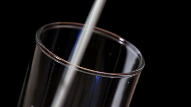 Remplissage en verre avec du lait en fond noir 