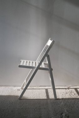 Beton zemin ile boş bir odada zarif beyaz sandalye.