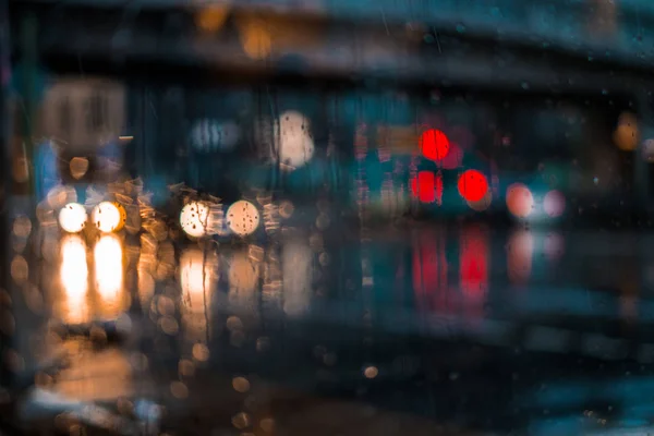 Ночная жизнь города через лобовое стекло: автомобили, огни и дождь . — стоковое фото