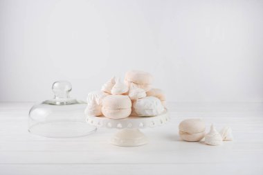 Marshmallow bej ve beyaz bir pasta stand üzerine yığılmış.